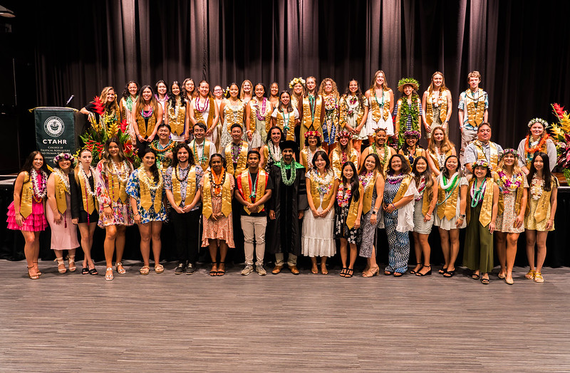 CTAHR Spring 2024 Convocation graduating students wearing leis at UHM Campus Center Ballroom stage